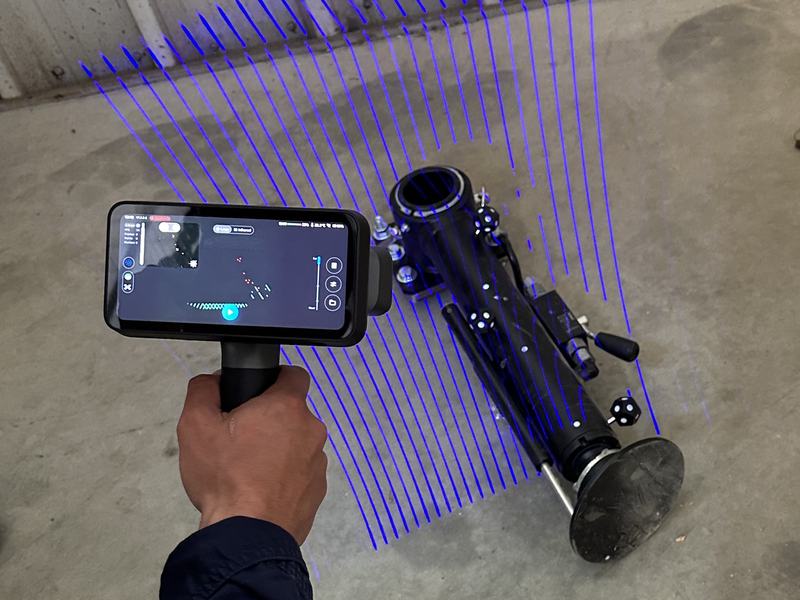 Handheld 3D laser scanner scanning a machine part